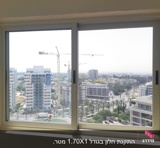 חלון אלומיניום עם נוף עירוני ברקע